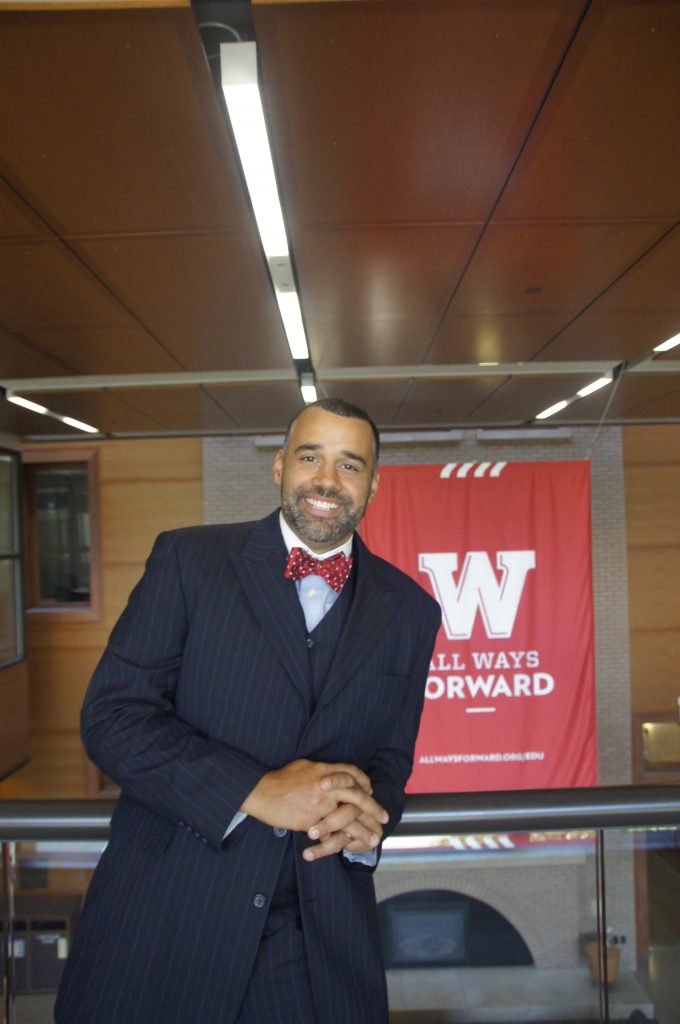 Shawn Robinson smiling in front of red Wisconsin banner.